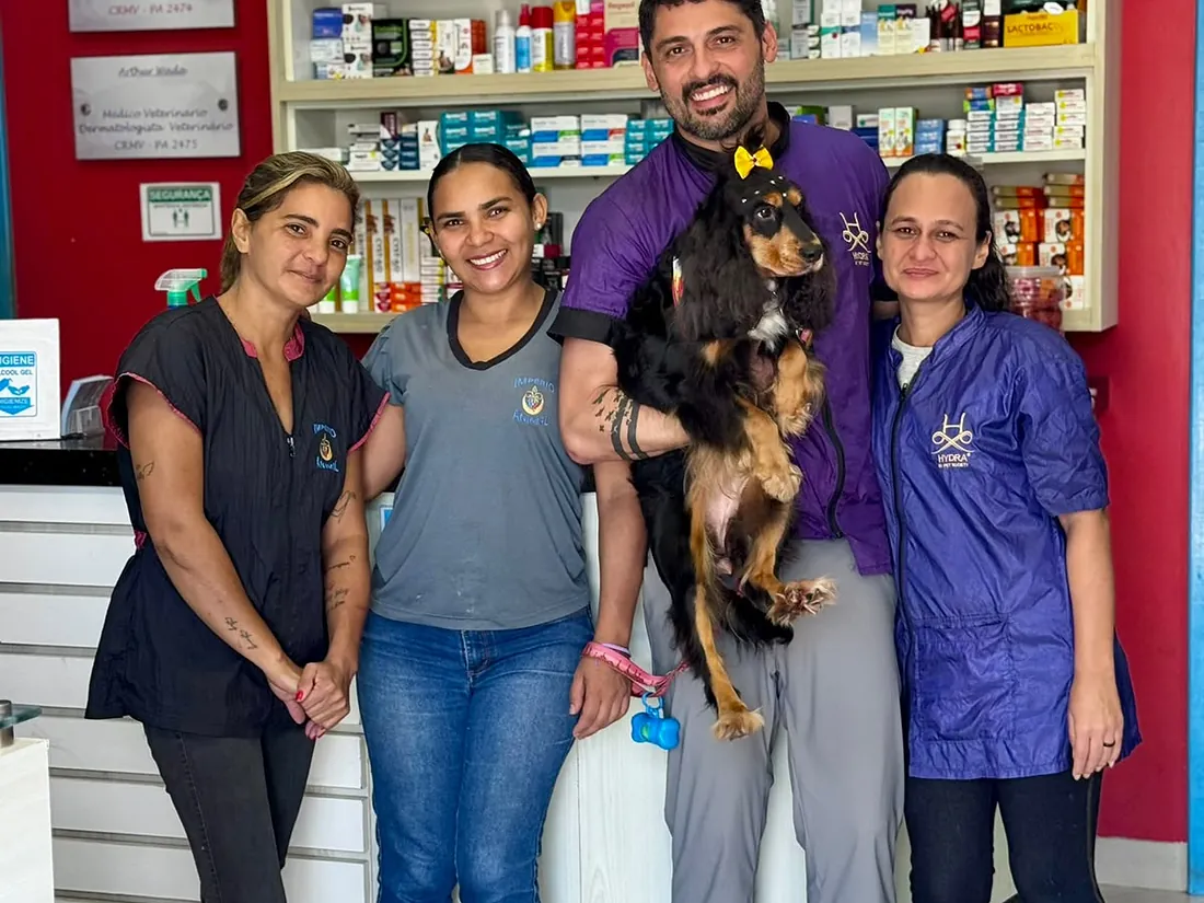 Recepção do Espaço Vila Animal com a equipe e um cão no colo